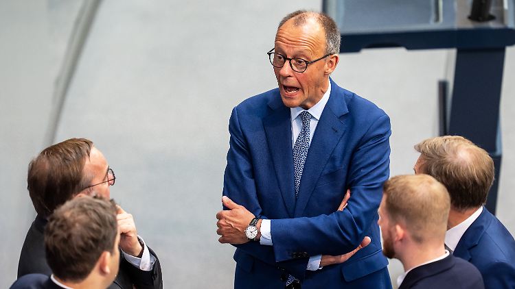 Merz im Gespräch mit Koalitionspolitikern an einem denkwürdigen Tag im Plenum.