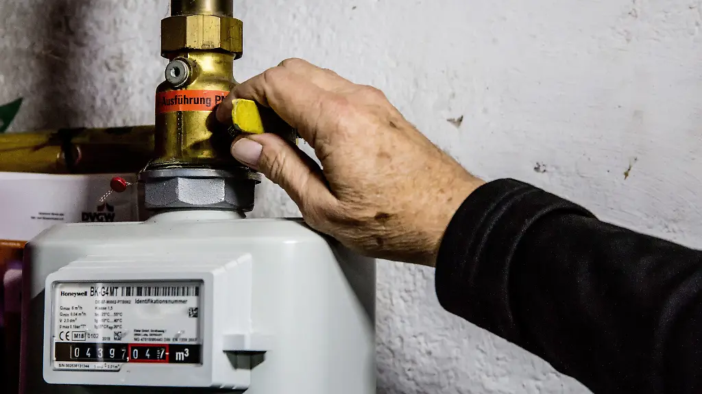 Eine-Person-dreht-im-Wohnhaus-den-Haupthahn-der-Erdgaszuleitung-fuer-die-Gasheizung-des-Hauses-ab