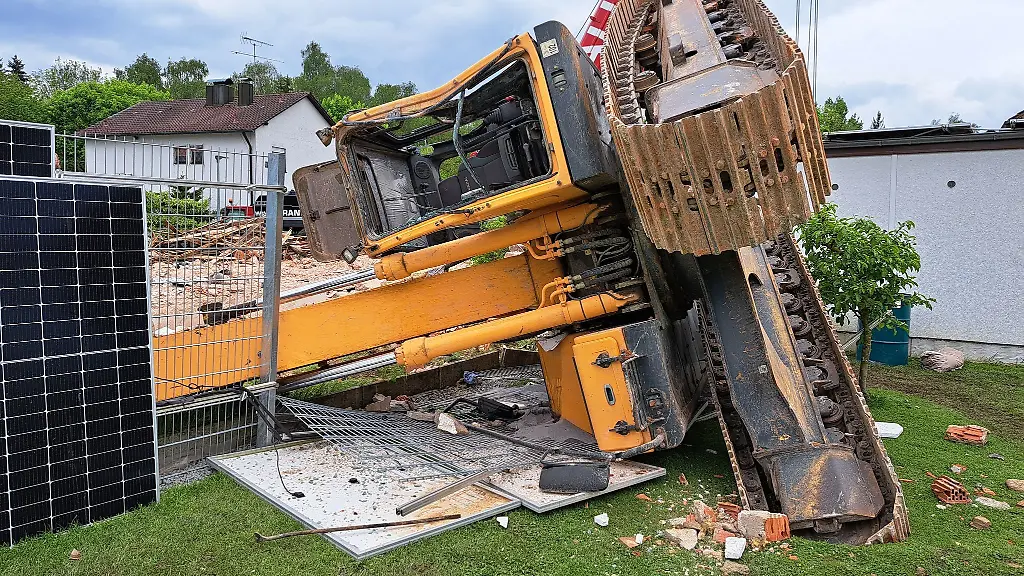 Ein-Bagger-ist-bei-Abrissarbeiten-in-einen-angrenzenden-Garten-gekippt