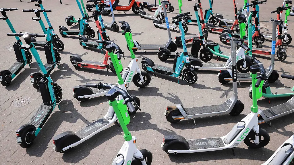 E-Scooter-von-unterschiedlichen-Anbietern-stehen-auf-einem-Gehweg