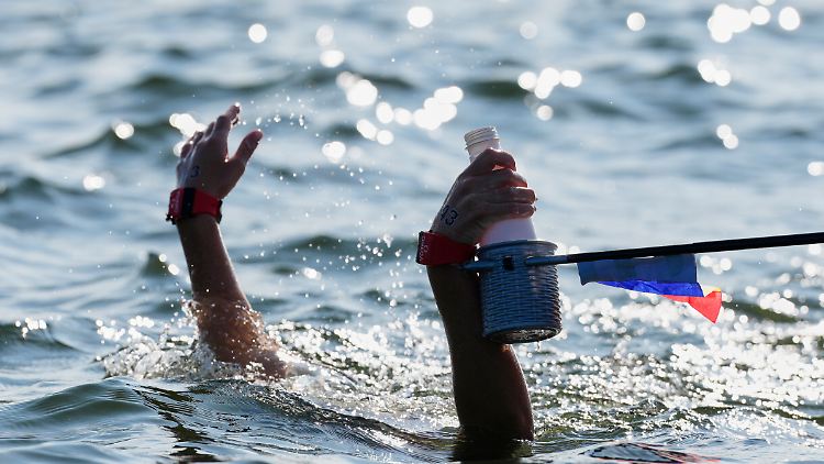Wasser im Wasser: Eine Schwimmerin bekommt ein Getränk gereicht.