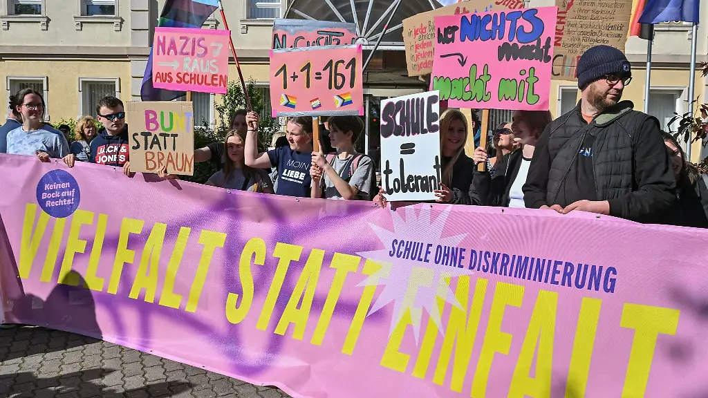 Teilnehmer-der-Demonstration-Vielfalt-statt-Einfalt-Schule-ohne-Diskriminierung-stehen-mit-Schildern-und-Plakaten-vor-dem-Schulamt-in-Cottbus
