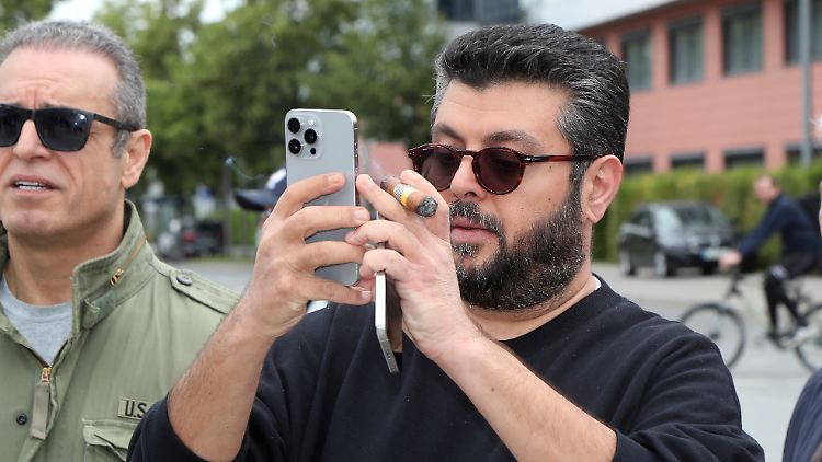 Ein Investor, wie er im Buche steht: Hasan Ismaik mit Zigarre und zwei Smartphones in der Hand.