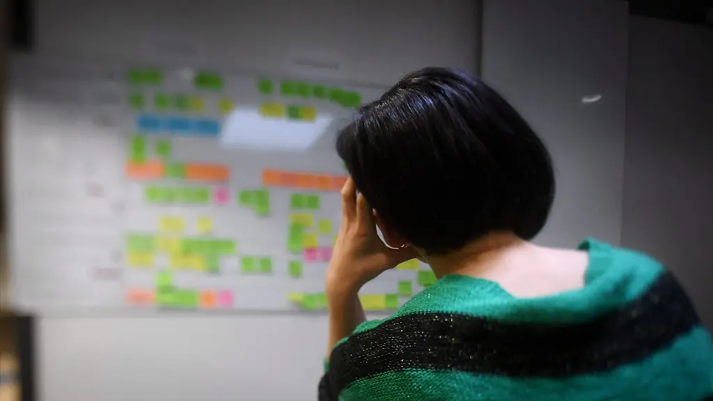 Eine-Mitarbeiterin-in-einem-Buero-stuetzt-den-Kopf-auf-die-Hand