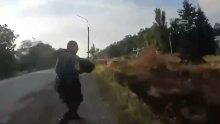 Ukrainische Soldaten steigen nach Beschuss in Pokrowsk aus einem Auto. Danach trifft eine russische Drohne das Fahrzeug.