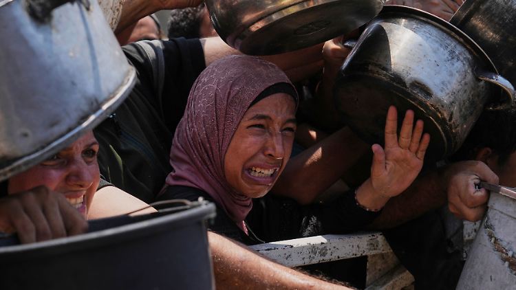 Palästinenser kämpfen um gespendete Lebensmittel in einer Gemeinschaftsküche in Gaza-Stadt im nördlichen Gazastreifen.