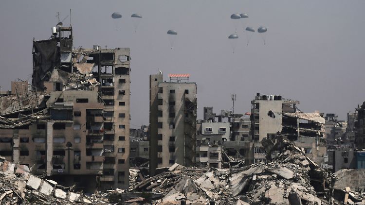 Humanitäre Hilfe wird über Gaza-Stadt abgeworfen und schwebt an Fallschirmen zu Boden.