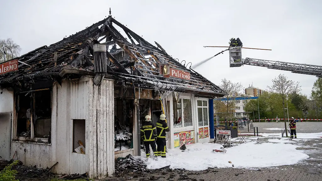 Feuerwehrleute-loeschen-einen-Gebaeudebrand-in-einer-Pizzeria-Die-Stralsunder-Pizzeria-ist-bei-dem-Feuer-weitgehend-zerstoert-worden-Ein-Mensch-sei-bei-dem-Brand-augenscheinlich-verletzt-und-mit-Verdacht-auf-Rauchvergiftung-in-ein-Krankenhaus-gebracht-worden-wie-die-Polizei-mitteilte