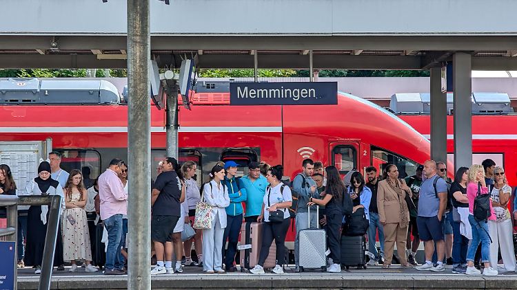 Menschen warten in Memmingen auf einen Zug. Mit dem Deutschlandticket müssen sie im Regionalverkehr kein zusätzliches Ticket kaufen.