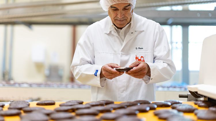 Der Betriebsleiter bei Lebkuchen Schmidt prüft stichprobenartig die Qualität frisch gebackener Lebkuchen.