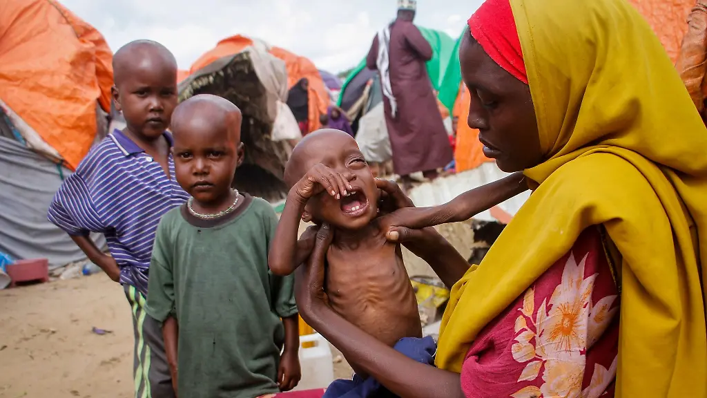 Maryan-Madey-r-die-aus-der-von-Duerre-heimgesuchten-Region-Lower-Shabelle-geflohen-ist-haelt-ihre-unterernaehrte-Tochter-Deka-Ali-in-einem-Lager-fuer-Vertriebene-am-Stadtrand-von-Mogadischu