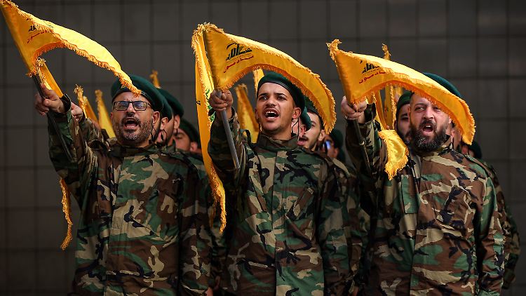 Pro-iranische Hisbollah-Kämpfer skandieren Parolen. 