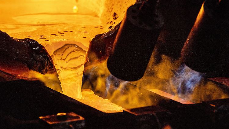 Geschmolzenes Gold fließt in eine Barrenform.