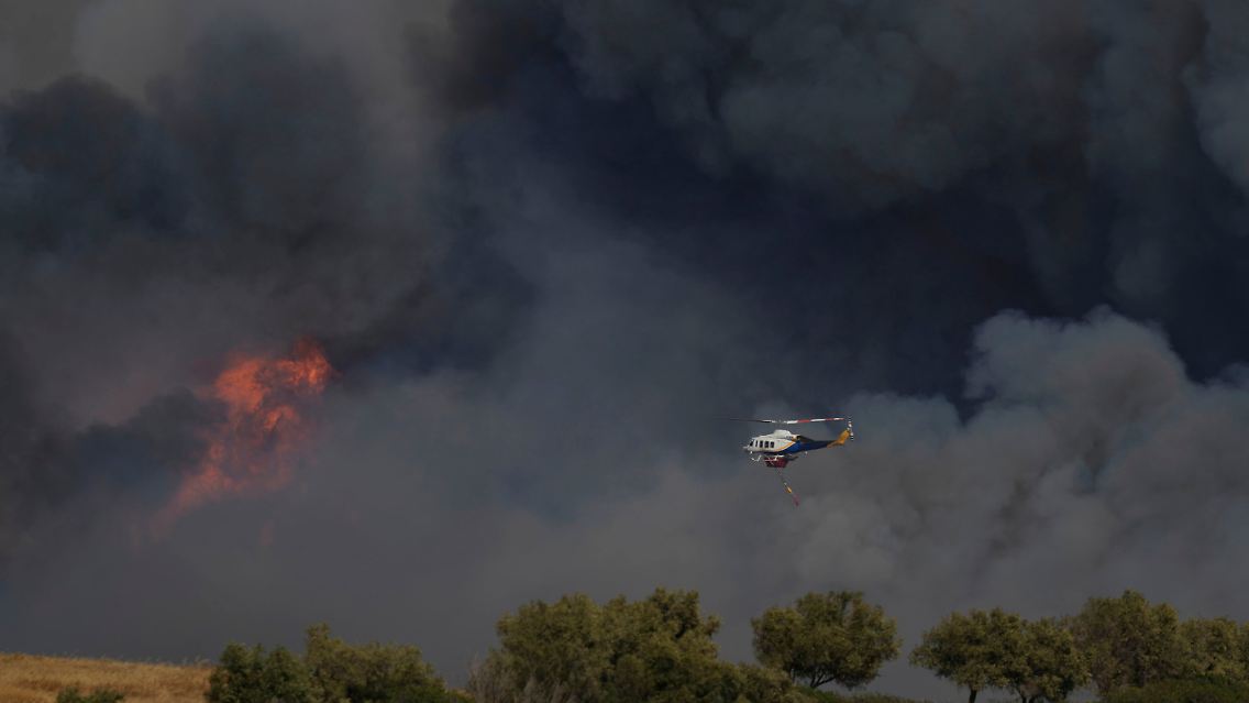 Ein Hubschrauber fliegt durch den Rauch in Keratea, einem Außenbezirk von Athen.