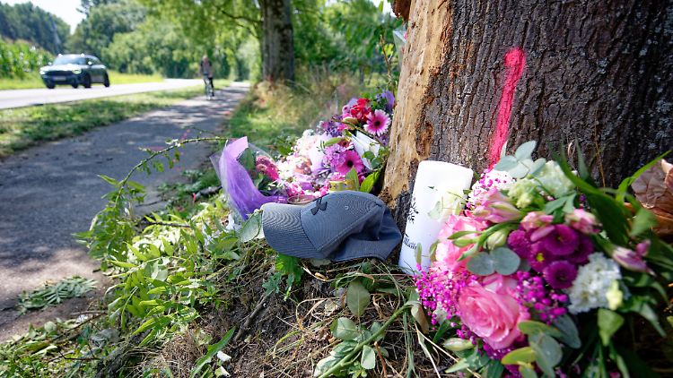 Blumen, Kerzen und eine Mütze erinnern an der Unfallstelle an die Verstorbenen.