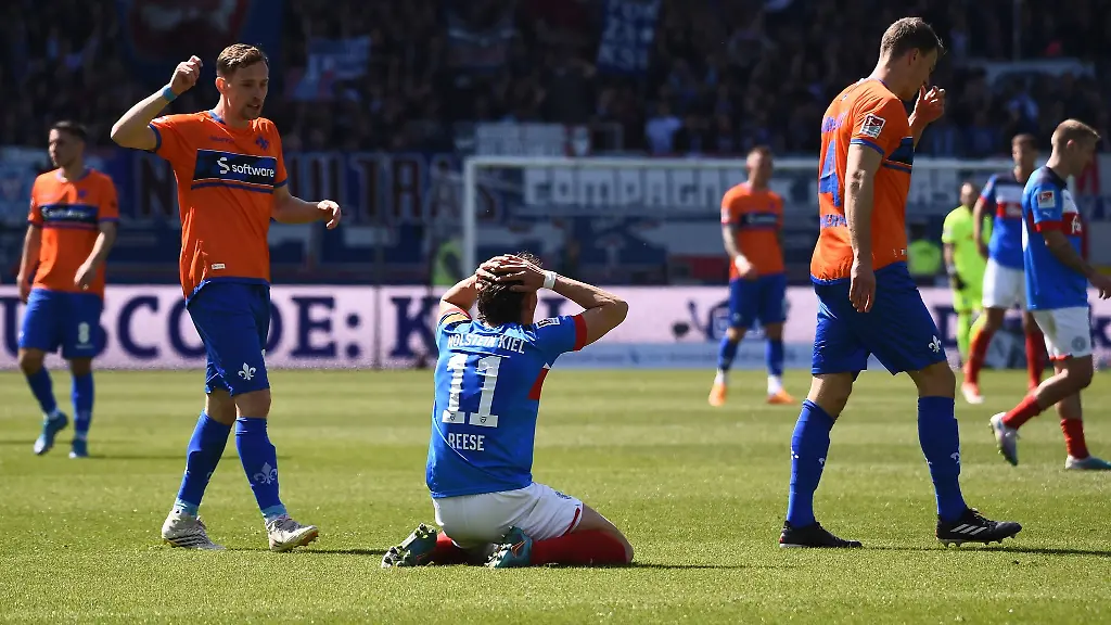 Kiels-Fabian-Reese-M-kniet-auf-dem-Rasen-und-schlaegt-nach-einer-vergebenen-Chance-die-Haende-ueber-dem-Kopf-zusammen