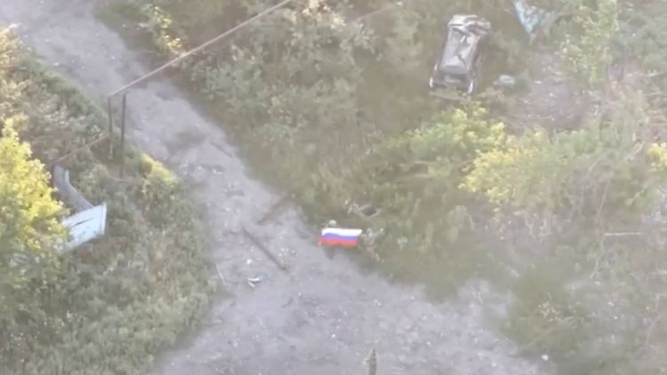Russische Soldaten schwenken die russische Flagge in der laut Moskau jüngst eingenommenen ukrainischen Siedlung Jablonowka.
