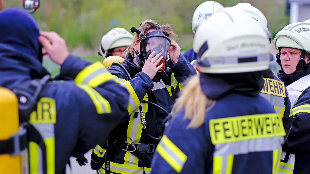 Kameraden-der-Freiwilligen-Feuerwehr-Dorf-Mecklenburg-beim-Anlegen-ihrer-Schutzausruestung
