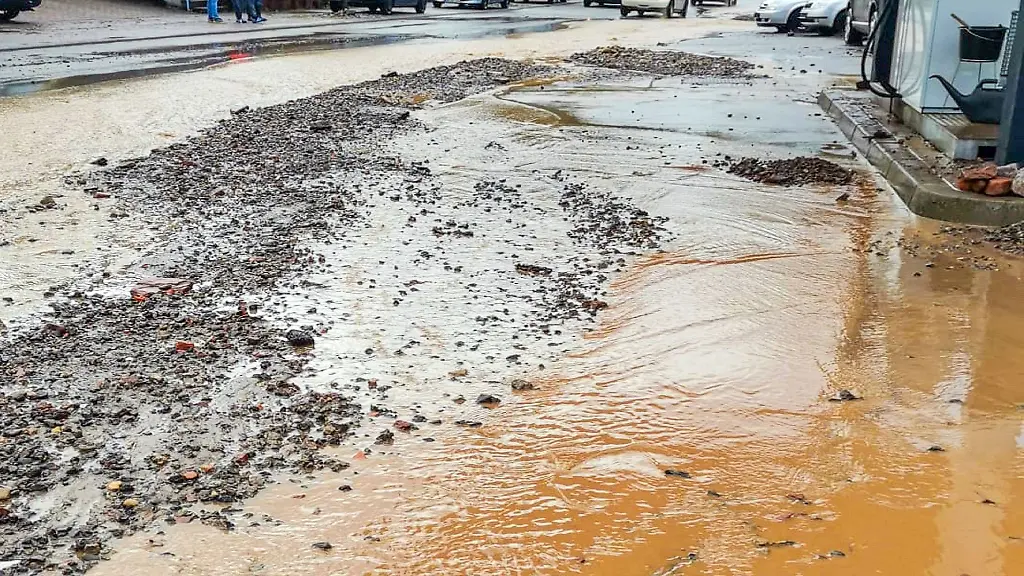 Eine-ueberflutete-Strasse-ist-nach-einem-Unwetter-bei-einer-Tankstelle-zu-sehen