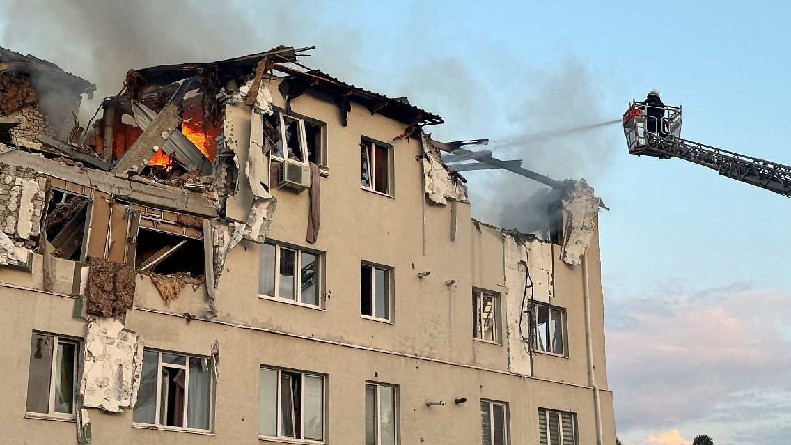 Feuerwehrleute löschen ein zerstörtes Wohnhaus in Charkiw.