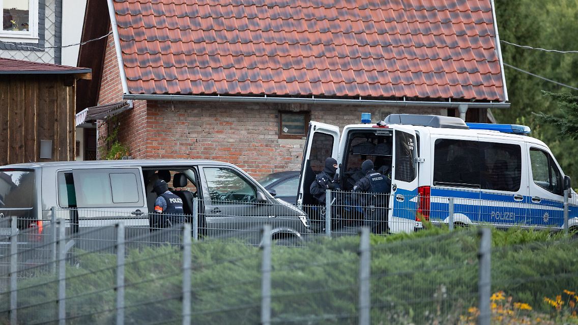 Thüringen, Schleusingen: Polizeibeamte stehen vor einem Haus.