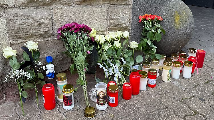 Blumen und Kerzen stehen am Tatort.