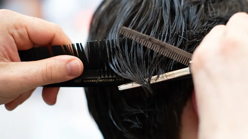 Ein-Friseur-schneidet-einem-Kunden-im-Salon-die-Haare