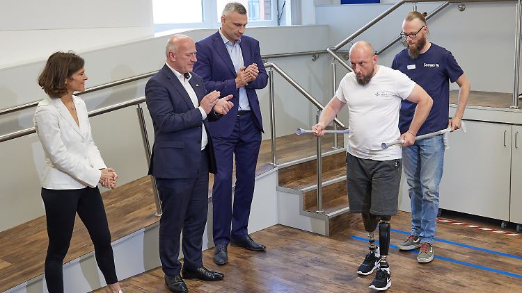Berlins Bürgermeister Kai Wegner (2.v.l.) und sein Kiewer Amtskollege Vitali Klitschko schauen bei Gehübungen im Rahmen des Projekts "Prothesenzentrum Berlin-Kiew" zu.