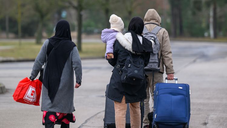 Menschen verlassen das Gelände der Zentralen Ausländerbehörde Brandenburgs in Eisenhüttenstadt.