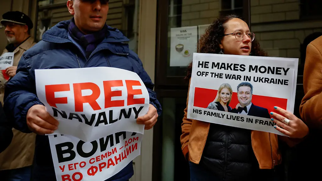 Demonstranten-in-Paris-halten-Schilder-hoch-Er-verdient-Geld-mit-dem-Krieg-in-der-Ukraine-dazu-ein-Bild-von-Swetlana-Manjowitsch-und-dem-russischen-Vize-Verteidigungsministers-Timur-Iwanow