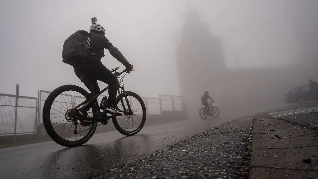 Zwei-Mountainbiker-sind-auf-einer-nassen-Strasse-unterwegs