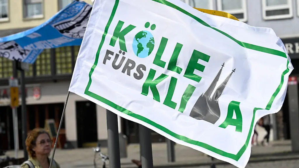 Eine-Teilnehmerin-am-bundesweiten-Aktionstag-unter-dem-Motto-Mobilitaetswende-jetzt-haelt-in-Koeln-eine-Fahne-mit-Aufschrift