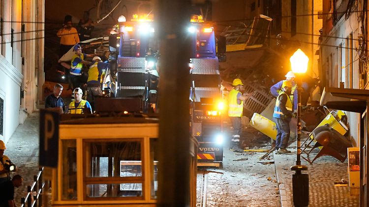 Arbeiter beseitigen die Trümmer der entgleisten und verunglückten Standseilbahn in Lissabon.