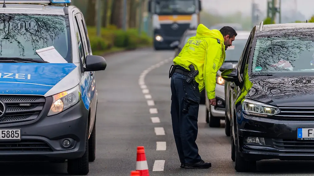 Ein-Polizeibeamter-spricht-auf-der-Heerstrasse-in-Frankfurt-einen-Autofahrer-an
