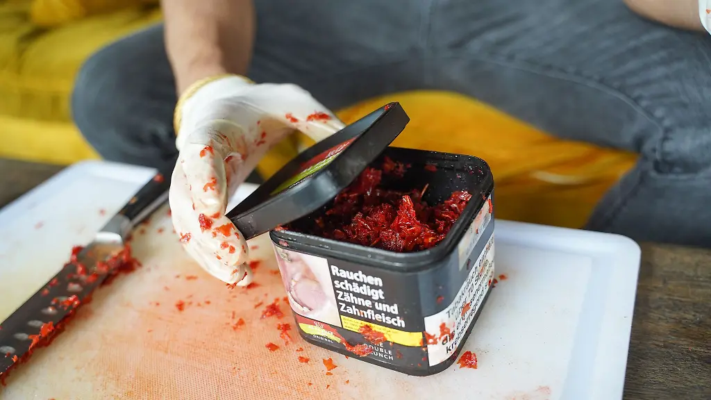 Eine-Dose-mit-Wasserpfeifentabak-wird-geoeffnet