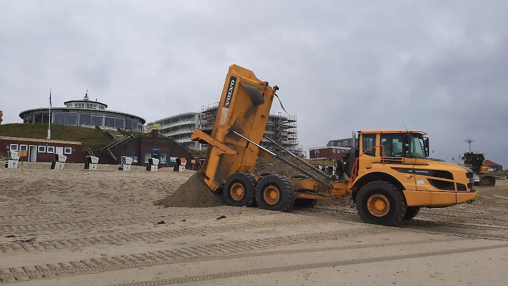 Ein-Muldenkipper-schuettet-am-Badestrand-der-ostfriesischen-Insel-Wangerooge-fehlenden-Sand-auf
