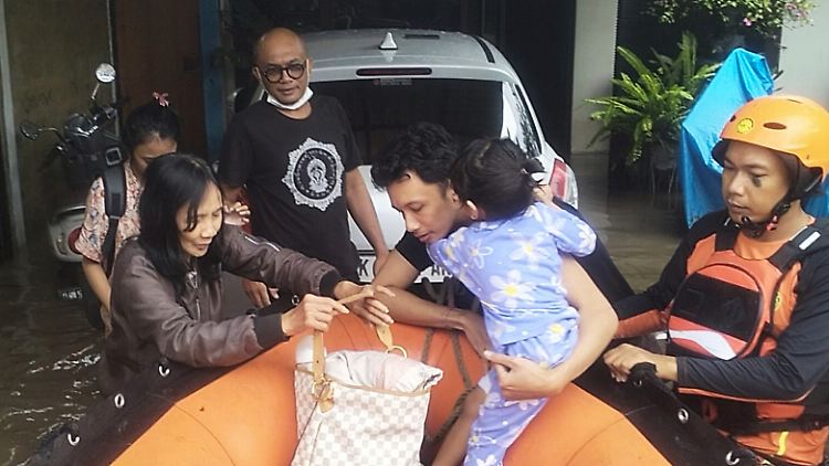 Rettungskräfte evakuieren Bewohner aus ihrem überfluteten Haus in Denpasar, Bali.