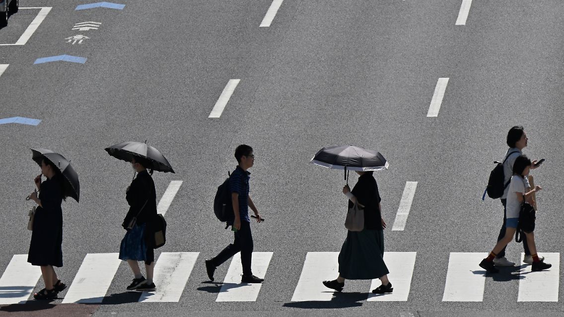 Im Sommer bewegen sich zahlreiche Bewohner von Tokio nur unter dem Schutz ihrer Schirme.