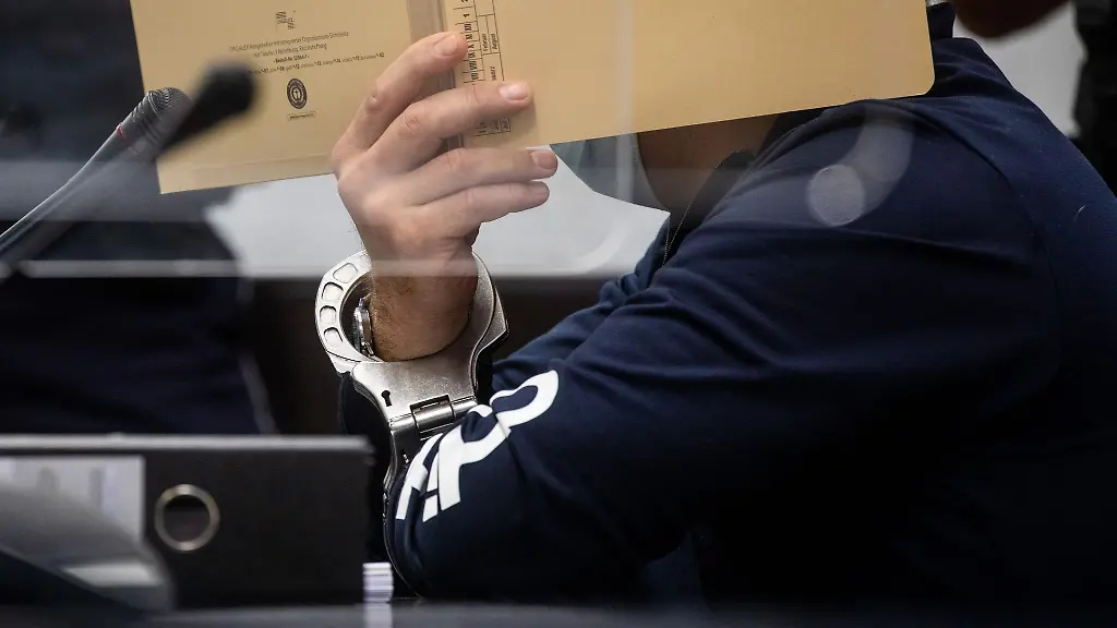 Zum-Auftakt-eines-Mordprozesses-sitzt-der-angeklagte-Mann-mit-Handschellen-in-einem-Saal-des-Landgerichts-Stuttgart-auf-seinem-Platz