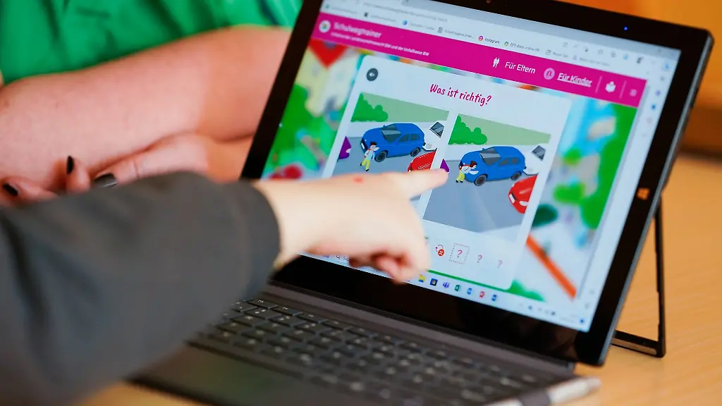 Ein-Kindergartenkind-zeigt-auf-eine-auf-einem-Tablet-geoeffnete-Internetseite-des-Schulwegtrainers