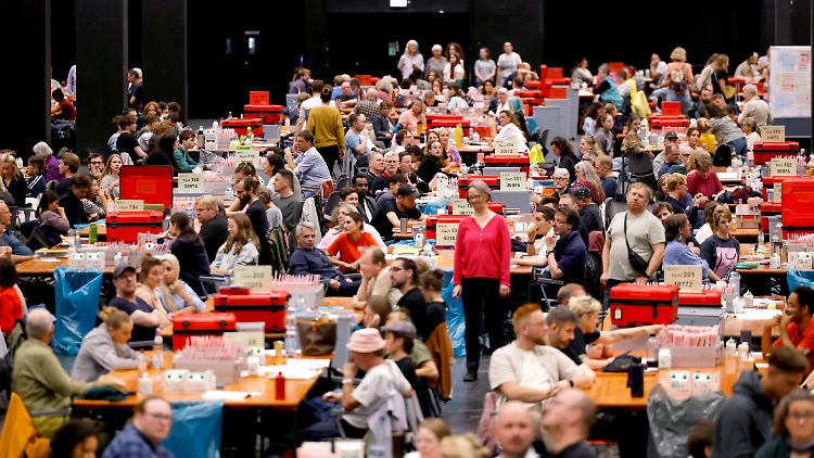 Ehrenamtliche Wahlhelfer sind in Köln bei der Arbeit. 