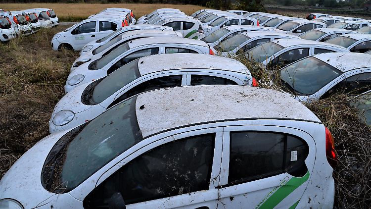 Verlassene Elektrofahrzeuge des Charsharing-Anbieters Evcard stehen auf einem Feld in der Stadt Jiaxing in der ostchinesischen Provinz Zhejiang.