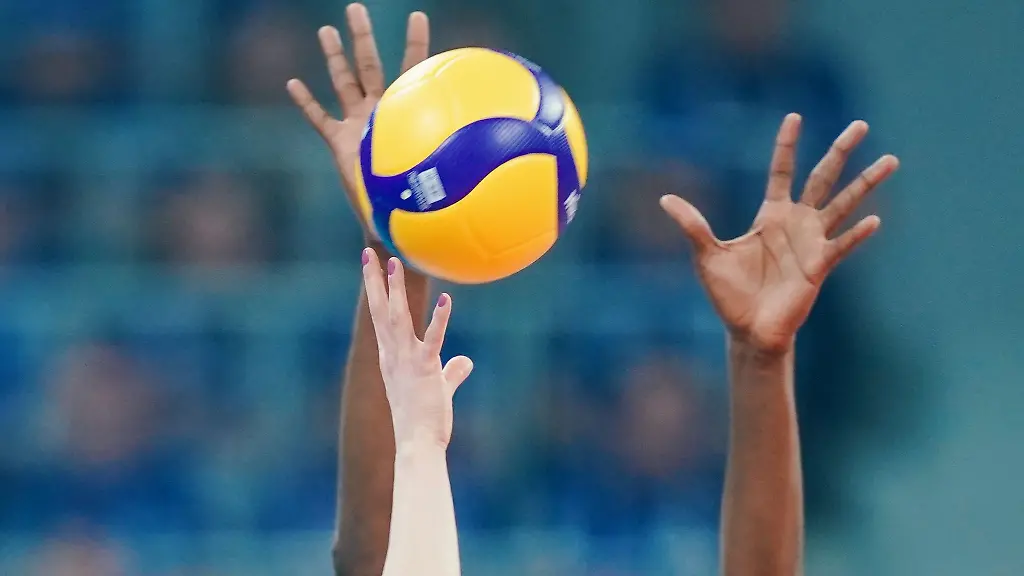 Spielerinnen-strecken-ihre-Arme-in-Richtung-eines-Volleyballs