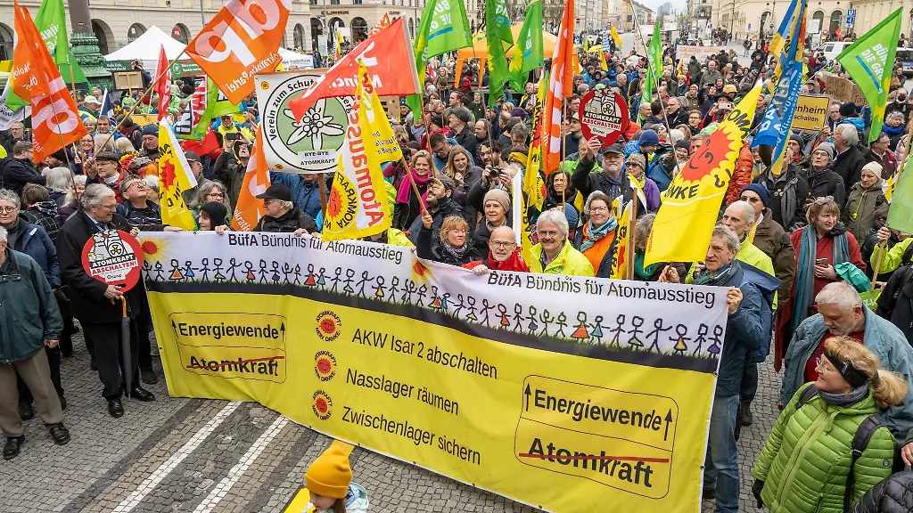 Menschen-mit-Plakaten-und-Fahnen-nehmen-an-einer-Kundgebung-vom-Buendnis-fuer-Atomausstieg-teil