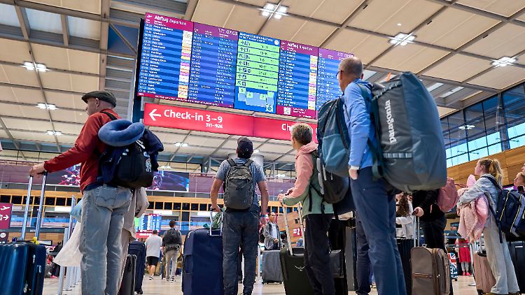 Fluggäste informieren sich an den Abflugtafeln im Terminal 1 des Flughafens Berlin Brandenburg. 