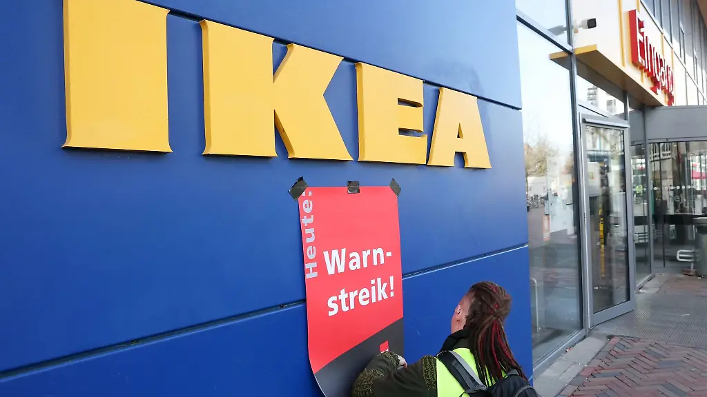 Waehrend-eines-Warnstreiks-wird-ein-Plakat-mit-der-Aufschrift-Warnstreik-angebracht