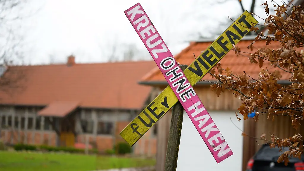 Ein-Holzkreuz-mit-der-Aufschrift-Kreuz-ohne-Haken-fUEr-Vielfalt-steht-an-einer-Hofeinfahrt