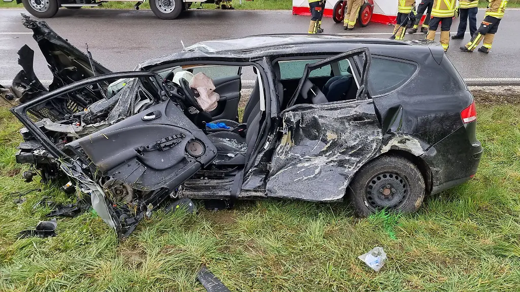 Rettungskraefte-stehen-an-der-Unfallstelle-Bei-einem-Frontalzusammenstoss-eines-Autos-mit-einem-Lkw-ist-eine-Autofahrerin-bei-Neustadt-an-der-Donau-Landkreis-Kelheim-ums-Leben-gekommen