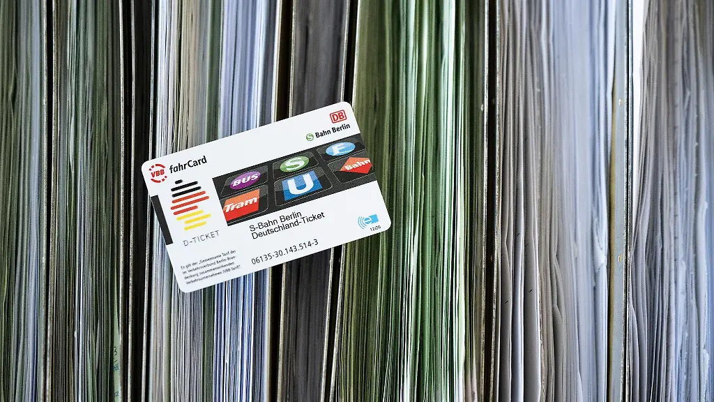 Eine-Deutschland-Ticket-Chipkarte-liegt-auf-sortierten-Abo-Antraegen