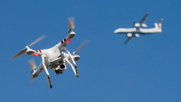 Eine private Drohne fliegt in weiter Entfernung von einem Flugzeug, das im Anflug auf den Flughafen Düsseldorf ist. (Symbolbild)
